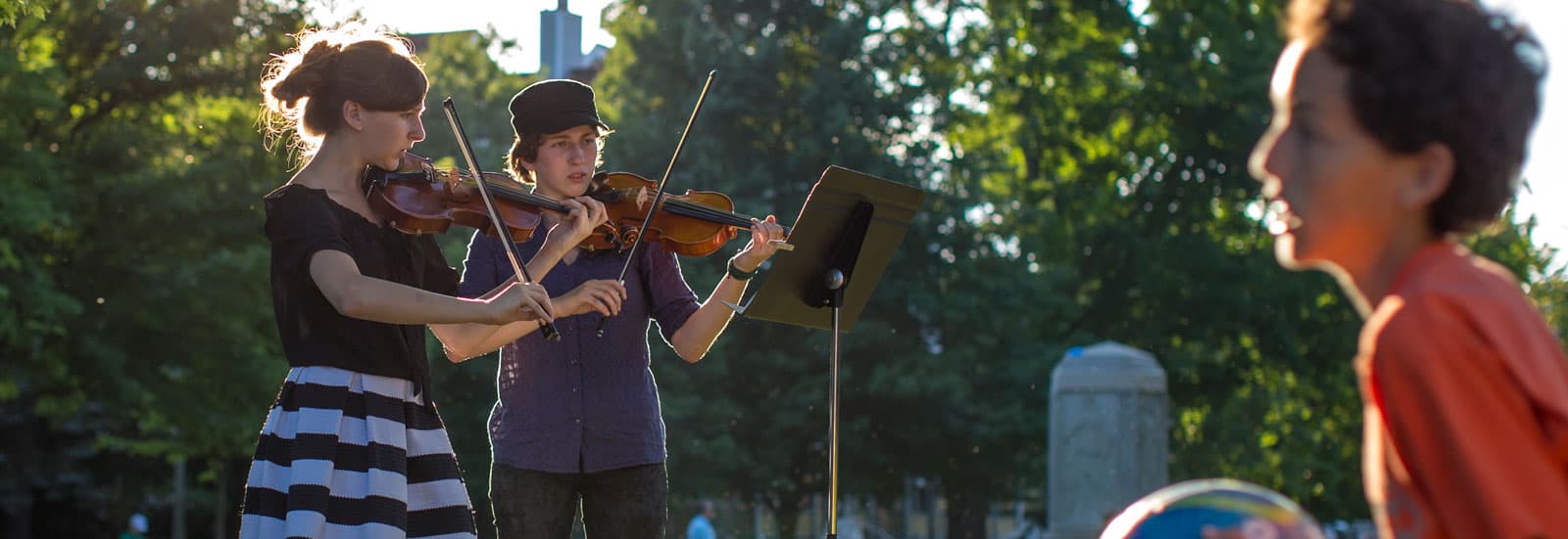 Music Festival Orchestra students playing violins in Bestor Plaza