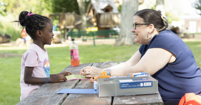 A woman and child at a picnic table