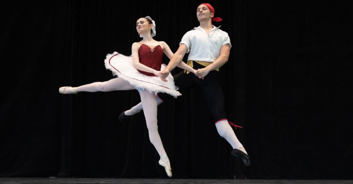 Two dancers leaping on stage
