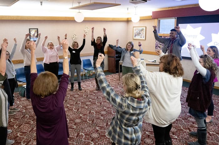 teachers raising their arms in the air during a workshop