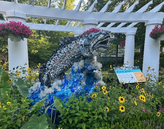 Nora the Salmon sculpture in a garden