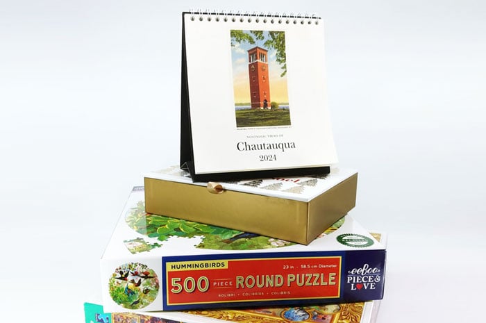 A Chautauqua calendar on top of a stack of puzzles