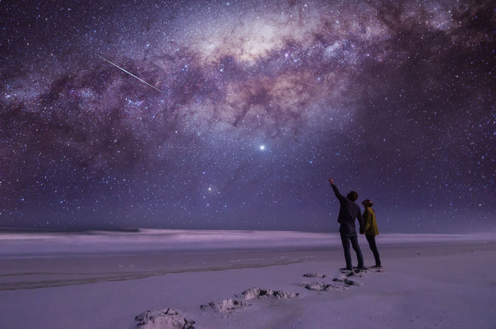 People gazing up at a shooting star in the snow