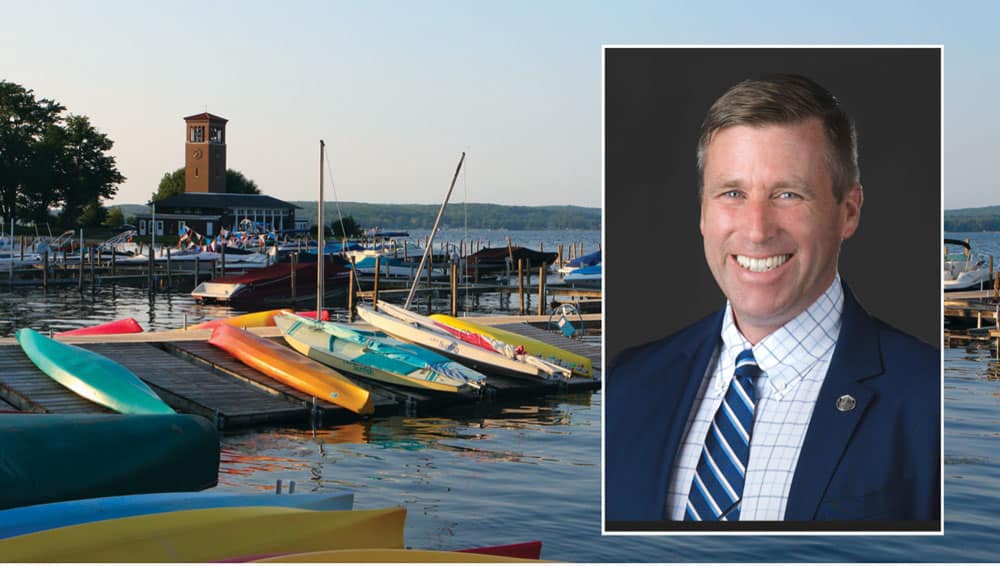 Michael Hill's headshot over a photo of kayaks in front of Miller Bell Tower along Chautauqua Lake