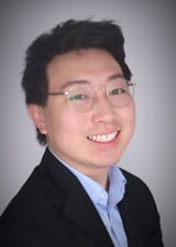 Sean Yang in a black suit and glasses