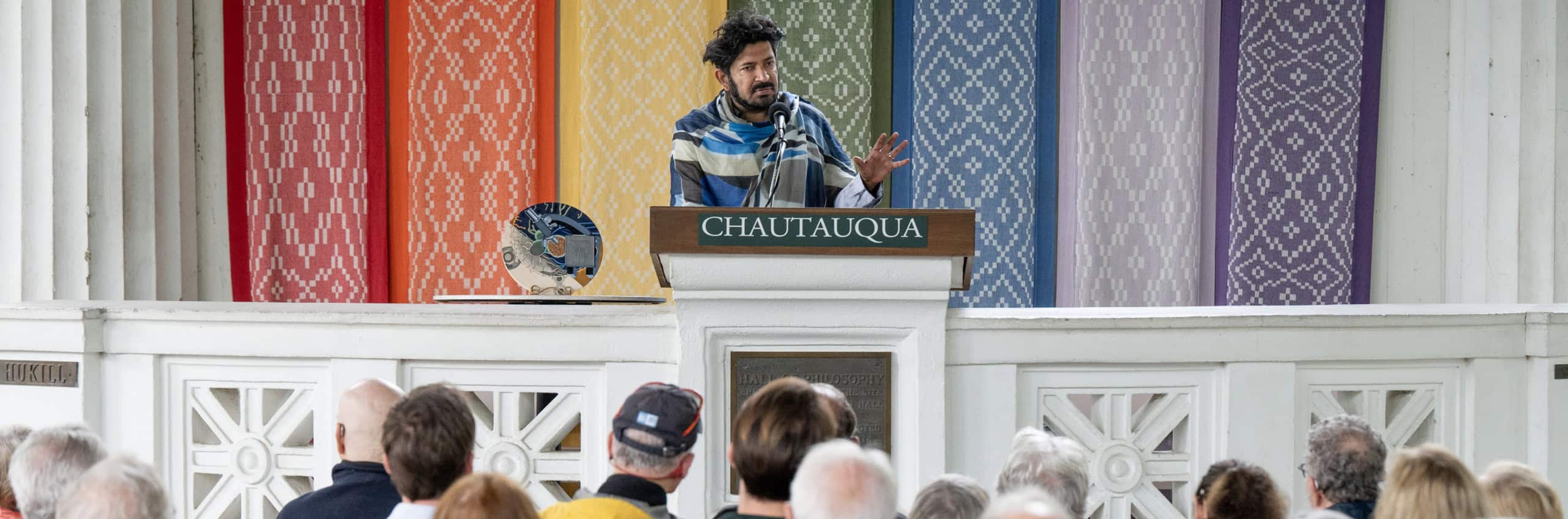 The 2023 Chautauqua Prize winner speaking to an audience in the Hall of Philosophy with the award next to them
