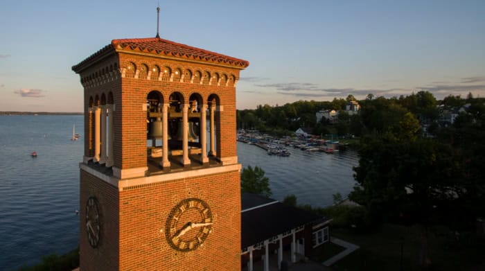 A close up of the Bell Tower at sunset with Chautauqua Lake behind it