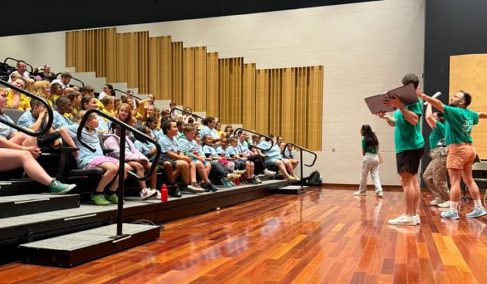 Students watching actors perform their plays