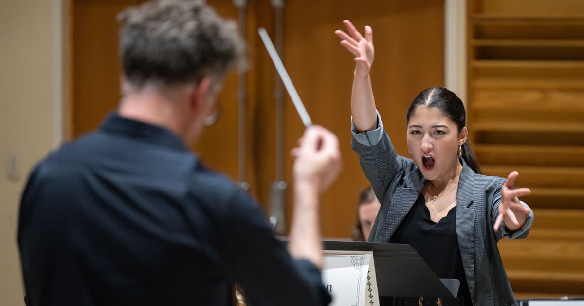 An opera singer and conductor during a performance
