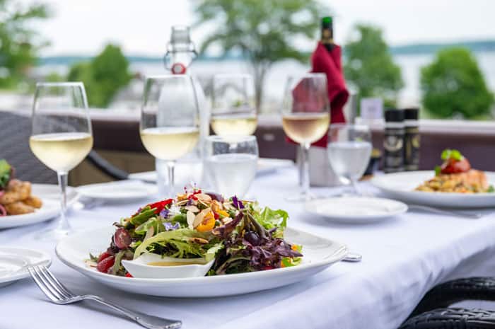 An outdoor table setting with wine and salad