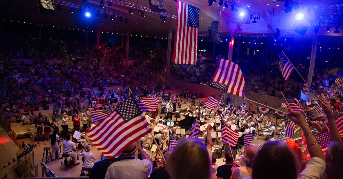 People waving American flags during a Chautauqua Symphony Orchestra concert