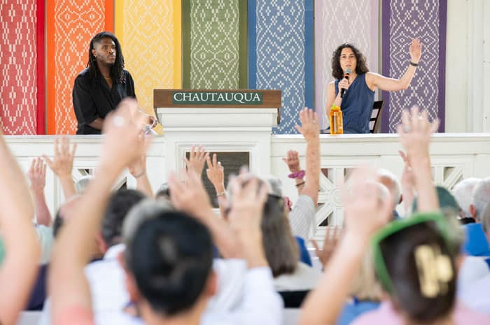 An audience raising their hands during a lecture