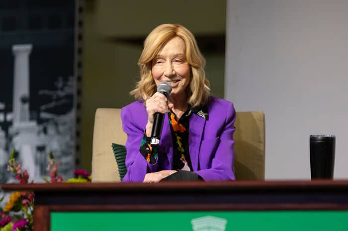 A woman in a purple blazer giving a lecture