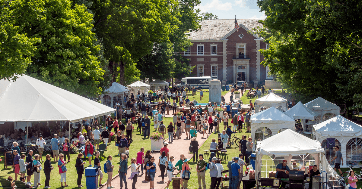 A crowd of people going to tents during the food festival